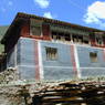 A house with painted stripes characteristic of Sakya sect religious affiliation near the Derge monastery.