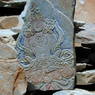 A carving of Amitayus in the prayer stone wall along the side of Derge? Monastery.