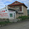 A building with message in Chinese and Tibetan house in the background.