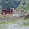 A Tibetan house made of logs and earthen walls.