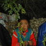 Young Tibetan girl sitting beneath a tree during a rain storm.
