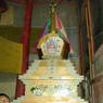 An elaborately decorated stupa inside a small shrine.