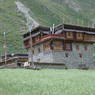 A Tibetan house with woven brush shading devices on the third story.