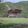 A Tibetan house with woven brush shading devices on the third story.