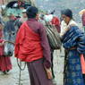 A Tibetan nun and nomad woman loading a horse.