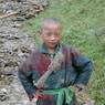 A Tibetan boy poses for the photographer on the side of the road.