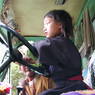 A young Tibetan girl at the wheel of a Landrover.