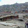 Panorama view of the center of the Larung Gar [bla rung gar] religious settlement with the Gyutrul Temple [sgyu 'phrul lha khang] (left) and Visitors Hostel (right) atop the ridge in back.