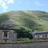 Tibetan houses near the hill with prayer flag arrangements.