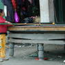 A young Tibetan girl playing pool on the street.