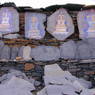 Close-up of carvings of stupas, deities, and prayers in the pile of prayer stones near the college.