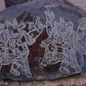 Close-up of carvings of deities in the pile of prayer stones near the college.