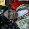 A Tibetan woman wearing a turquoise hair ornament and necklace.