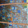 Close-up of buddhas, saints, and prayers carved and painted into a rock face.