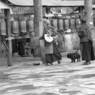 Pilgrims spinning prayer wheels and praying in front of the wall of carvings.