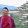 Monk Tashi Phuntsok with the monastery in the background.