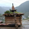A juniper incense burner built on top of a small wooden building.