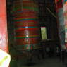 Lay Tibetans spinning a large prayer wheel.