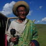 An elderly nomad spinning his prayer wheel and counting his rosary.