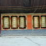 A row of prayer wheels flanking the entrance to the main temple.