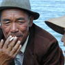An elderly Tibetan man enjoying a cigarette on the ferry.