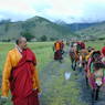 Abbot Dorji Tashi, lay Tibetans, and monks walking their horses along the road.