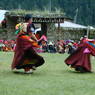 Monks dancing with small drums.