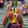 The Padmasambhava dancer presiding over the courtyard as other dancers return inside the monastery.