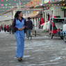 A young Tibetan woman walking on the street in Serta Town.