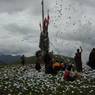 People offering paper prayer flags on top of one of the hills above Larung Gar.