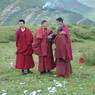 Four monks talking after offering paper prayer flags.