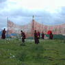 Monks near the prayer flag frame.