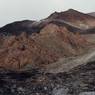 The mountainous formations at the site. The upper complex is located on the highest point of the reddish formation and the lower complex on the lower elevation summit. The middle complex is situated on the broad slopes linking these two summits.