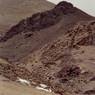 The ruins are found in the valley bottom and on the adjacent rocky slopes. Residential structures RS1, RS2 and RS3 are visible in the foreground.