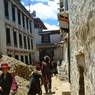 --Pilgrims  walking down lane towards rMe ru monastery.