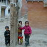 Three kids in front of Jo khang lha khang of 'Khor chags dgon pa