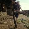 Bundles of split 'mah' on platform in front of Blacksmith houses