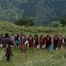 Bro performers moving up and up towards cypress tree as they recites and chants