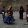 Champon (lead master) leading the dance while man with stick counterpart the child on the way