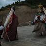 Gonpo and Gonmo dancing facing each other nearby Guru statue