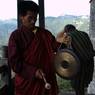 A Gomchen is hitting the gong to gather ritual performers after break