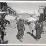 Street in Lhasa's Barkor with people and shops, and a stupa. Copyright Pitt Rivers Museum, University of Oxford 2001.35.161.1